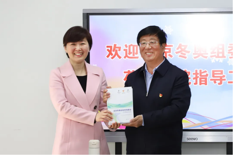 党委书记冯印涛与北京冬奥组委志愿者部副部长张丽娜互赠书籍